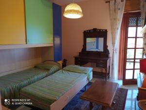 a bedroom with two beds and a mirror and a piano at Casa vacanze a Serra Scirocco in Trabia