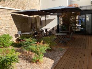 a patio with tables and an umbrella on a deck at Hôtel des Halles in Dijon