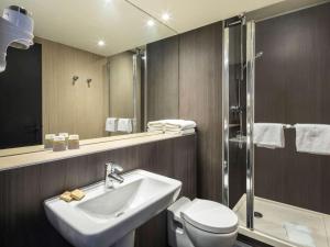 La salle de bains est pourvue d'un lavabo, de toilettes et d'une douche. dans l'établissement Mercure Versailles Chateau, à Versailles