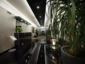 a hallway with plants in a room with at Hotel Versailles in Colorno