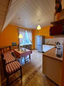 a kitchen with a table and a kitchen with yellow walls at Bei Chogman in Gronau