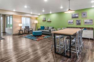 ein Wohnzimmer mit einem Tisch, Stühlen und einem Sofa in der Unterkunft WoodSpring Suites North Ft Worth Alliance TX Speedway in Fort Worth