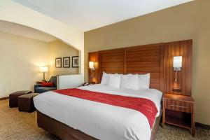 a hotel room with a large bed and a chair at Comfort Suites Southaven I-55 in Southaven
