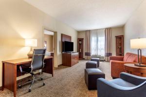 a hotel room with a desk and a couch at Comfort Suites Southaven I-55 in Southaven