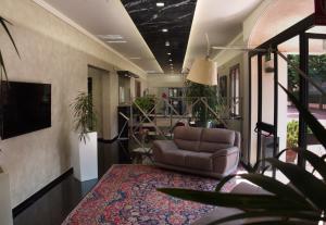 a living room with a leather chair and a rug at Hotel Versailles in Colorno