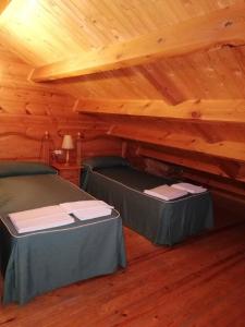 una camera con 2 letti in una baita di tronchi di CASA DE MADERA ZUMACAR I a Cazorla