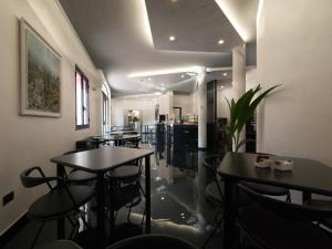 a restaurant with tables and chairs in a room at Hotel Versailles in Colorno