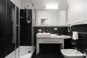 a black and white bathroom with a sink and a tub at UNO Design Hotel in Odesa