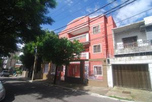 um edifício cor-de-rosa ao lado de uma rua em Refúgio Pousada Fortaleza em Fortaleza