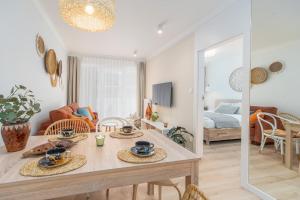 jadalnia i salon ze stołem i krzesłami w obiekcie BellMi Apartamenty - Parking Gratis, Plaża 5min, Komfort i Relaks w Kołobrzegu