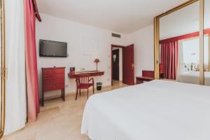 a bedroom with a bed and a desk at Hotel Cleopatra Palace in Playa de las Americas