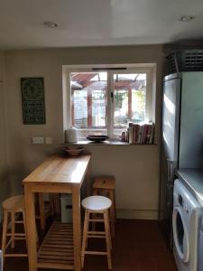 a small kitchen with a wooden table and a window at The Old Reading Room in Kingston