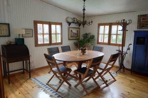 Un comedor con mesa y sillas de madera. en La isla de las sirenas, en Oruña