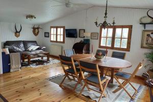 een woonkamer met een houten tafel en stoelen bij La isla de las sirenas in Oruña
