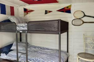 Litera en habitación con raquetas de tenis en la pared en La isla de las sirenas, en Oruña