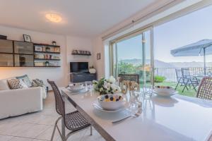 een eetkamer met een tafel en een groot raam bij La Dolce Vista in Perledo