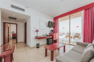 een woonkamer met een bank en een tafel bij Hotel Cleopatra Palace in Playa de las Americas