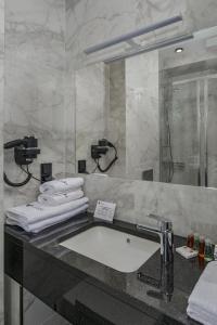 a bathroom with a sink and a mirror and towels at Hotel & Restauracja Gniecki in Hrubieszów