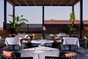 Atlantica Belvedere Resort - Adults Only في كاردامينا: مطعم بطاولات بيضاء وكراسي