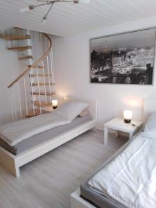 a white bedroom with a bed and a staircase at Marktstube in Marsberg