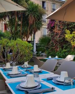 a table with chairs and umbrellas on a patio at Hotel Villa Victoria in Nice