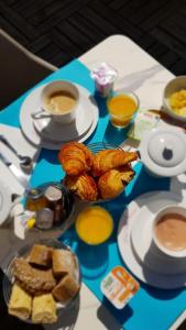 a table with a tray of pastries and cups of coffee at Hotel Villa Victoria in Nice