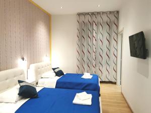 2 camas en una habitación de color azul y blanco en fiera camera en Verona