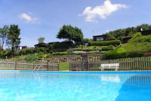 a large blue swimming pool with a wooden fence at Casa Lira Baumberge in Billerbeck