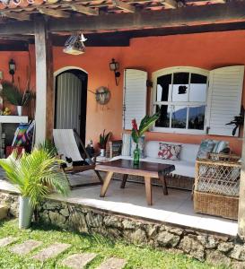 un patio con sofá y mesa frente a una casa en Casa na Feiticeira, en Ilhabela
