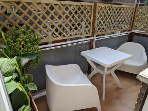 una pequeña mesa blanca y sillas en el balcón en B&B Gina Trastevere, en Roma