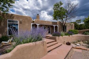 uma casa com um banco e flores roxas em frente em Luxury Private Villa in Santa Fe em Rancho Encantado
