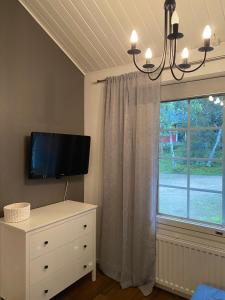 1 dormitorio con TV, vestidor y ventana en Apartment Suivakko, en Saariselkä 13 fotos más