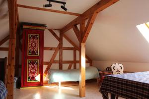 a attic room with a bed and wooden beams at le jardin du rempart in Westhoffen