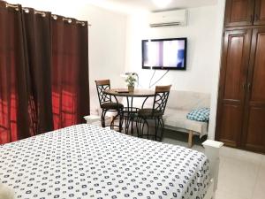 um quarto com uma cama, uma mesa e cadeiras em Caribbean Seaview apart Malecon Santo Domingo em Santo Domingo