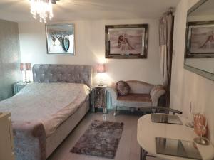 een slaapkamer met een bed, een bank en een tafel bij Secret Retreat in Bowness-on-Windermere