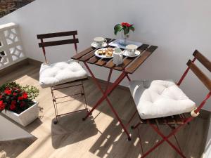 una mesa con un plato de comida y dos sillas en Camarote de la Villa, en Bueu