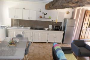 una cucina con un tavolo e una cucina con un frigorifero di Appartement de charme entre mer et montagne a Sollacaro