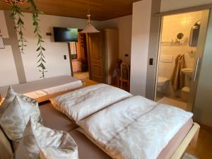 two beds in a room with a bathroom at Pension Görgen in Herresbach
