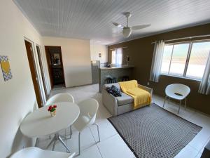 a living room with a couch and a table and chairs at Residencial Lúpulos in Angra dos Reis