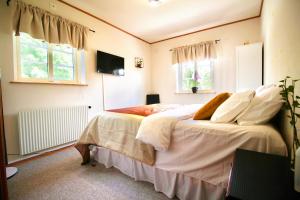 ein Schlafzimmer mit einem großen Bett mit weißer Bettwäsche und Kissen in der Unterkunft Alex's Family Villa in Sjöbo