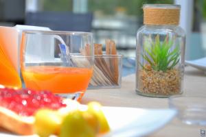 a table with a plate of food and a bottle of orange juice at B&b Mondello Resort in Palermo
