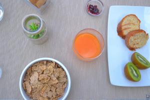 a table with a plate of food and a glass of orange juice at B&b Mondello Resort in Palermo