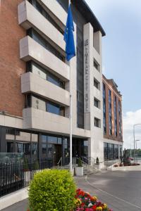 un edificio con una bandera azul delante de él en Limerick City Hotel, en Limerick