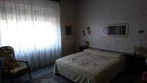 - une chambre avec un lit, une chaise et une fenêtre dans l'établissement Villa ROSA, à Lissone