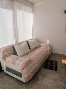 ein Sofa in einem Zimmer mit Fenster in der Unterkunft Kleines Haus im Oderbruch in Neutrebbin