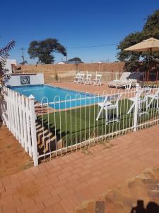 a white fence next to a swimming pool at Eagle Ranch Lodge in Mahikeng