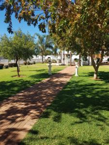 a path in a park with trees and grass at Eagle Ranch Lodge in Mahikeng