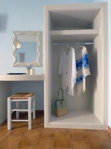 a room with a closet with a mirror and a stool at Tasoula Guest House in Adamantas