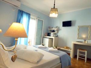 アダマスにあるTasoula Guest Houseのベッドルーム1室(ランプと暖炉付きのベッド1台付)