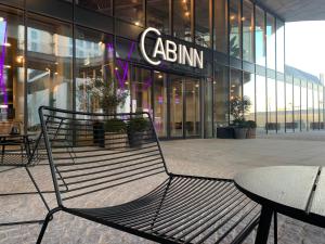 哥本哈根Cabinn Copenhagen的坐在大楼前的黑长凳